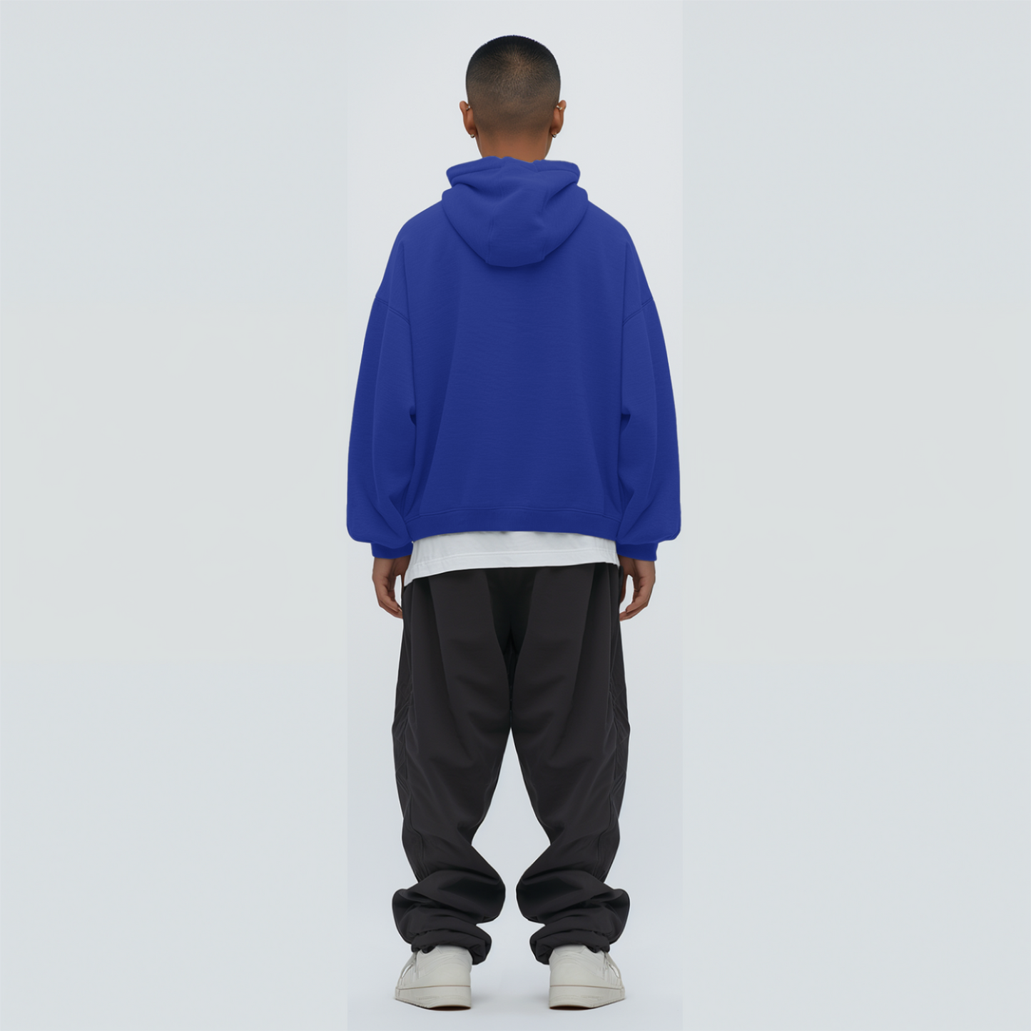 Person wearing a Royal blue hoodie and black pants on a white background