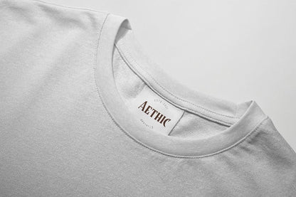 white t-shirt with 'AETHIC' label on a light gray background