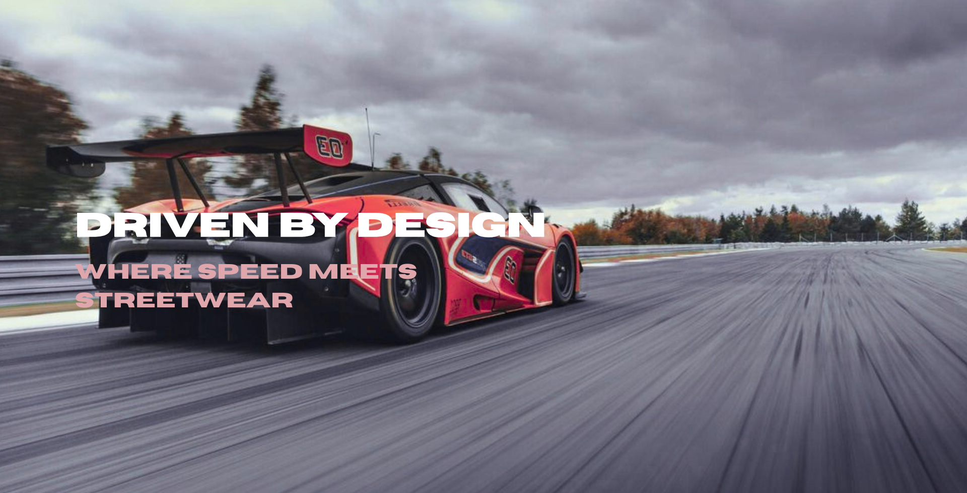Red and black race car on a track with 'Driven by Design' text overlay.