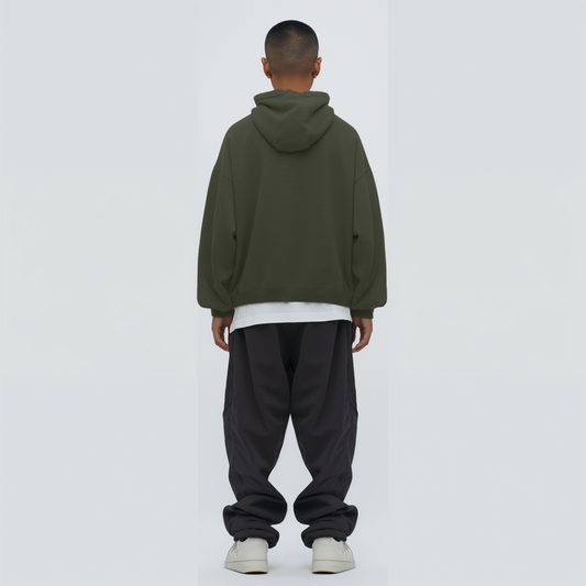Person wearing a Olive green hoodie and black pants on a white background