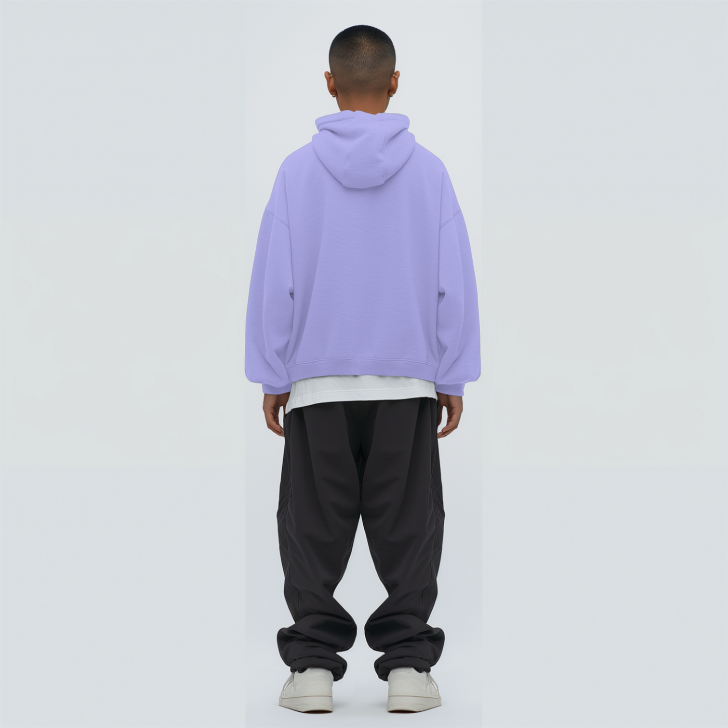 Person wearing a lavender hoodie and dark pants on a white background
