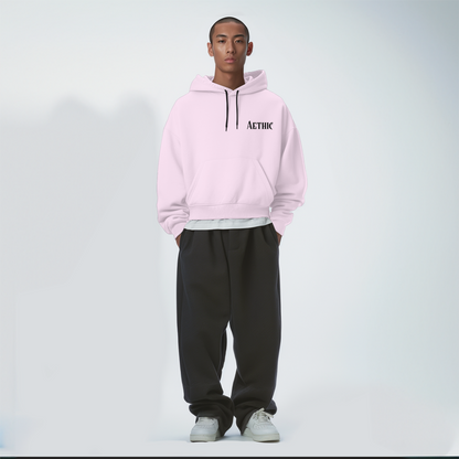Person wearing a light baby pink hoodie with 'ALTHIC' branding on a white background