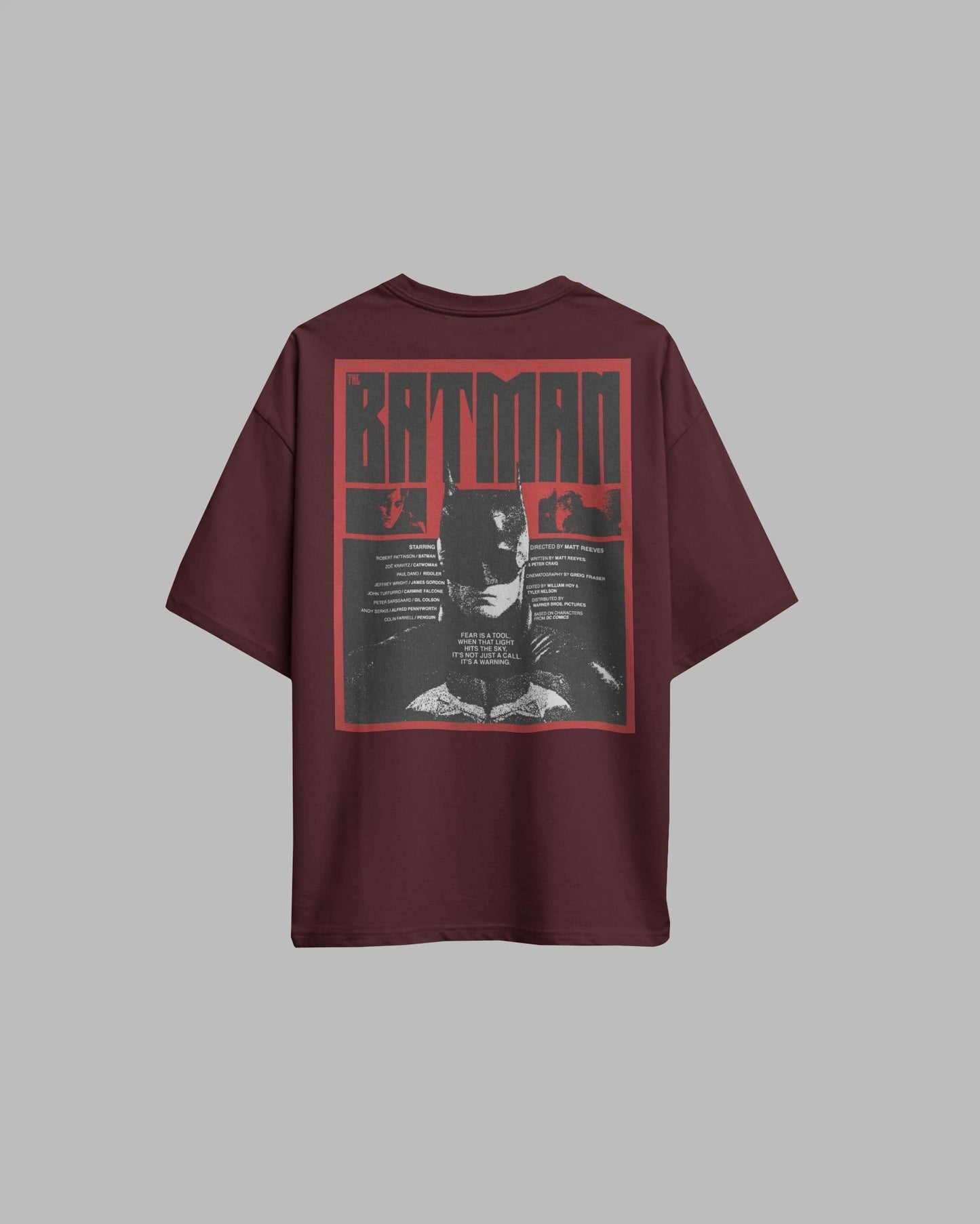 Maroon t-shirt with Batman graphic on the back against a gray background