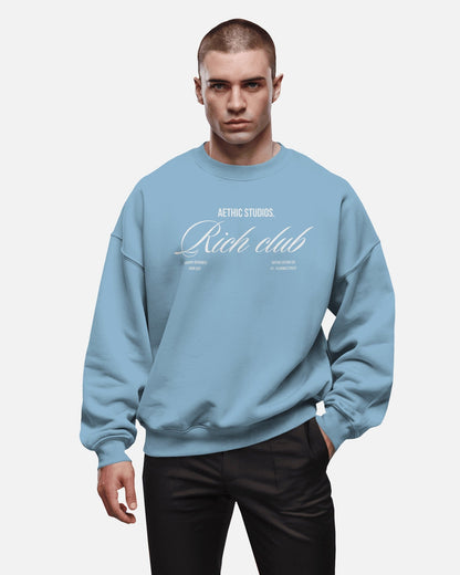 Front view of oversized sweatshirt with Rich Club text design and relaxed fit blue
