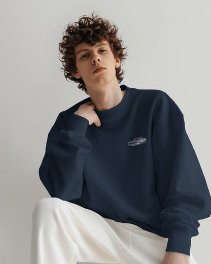 Person wearing a navy blue sweatshirt with a logo on a plain background
