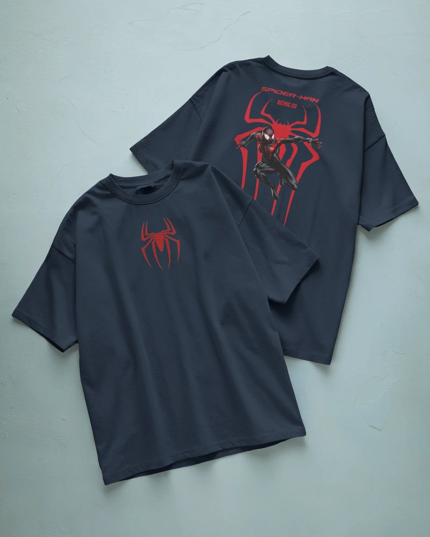 Two navy blue t-shirts with red spider graphic designs on a light gray background