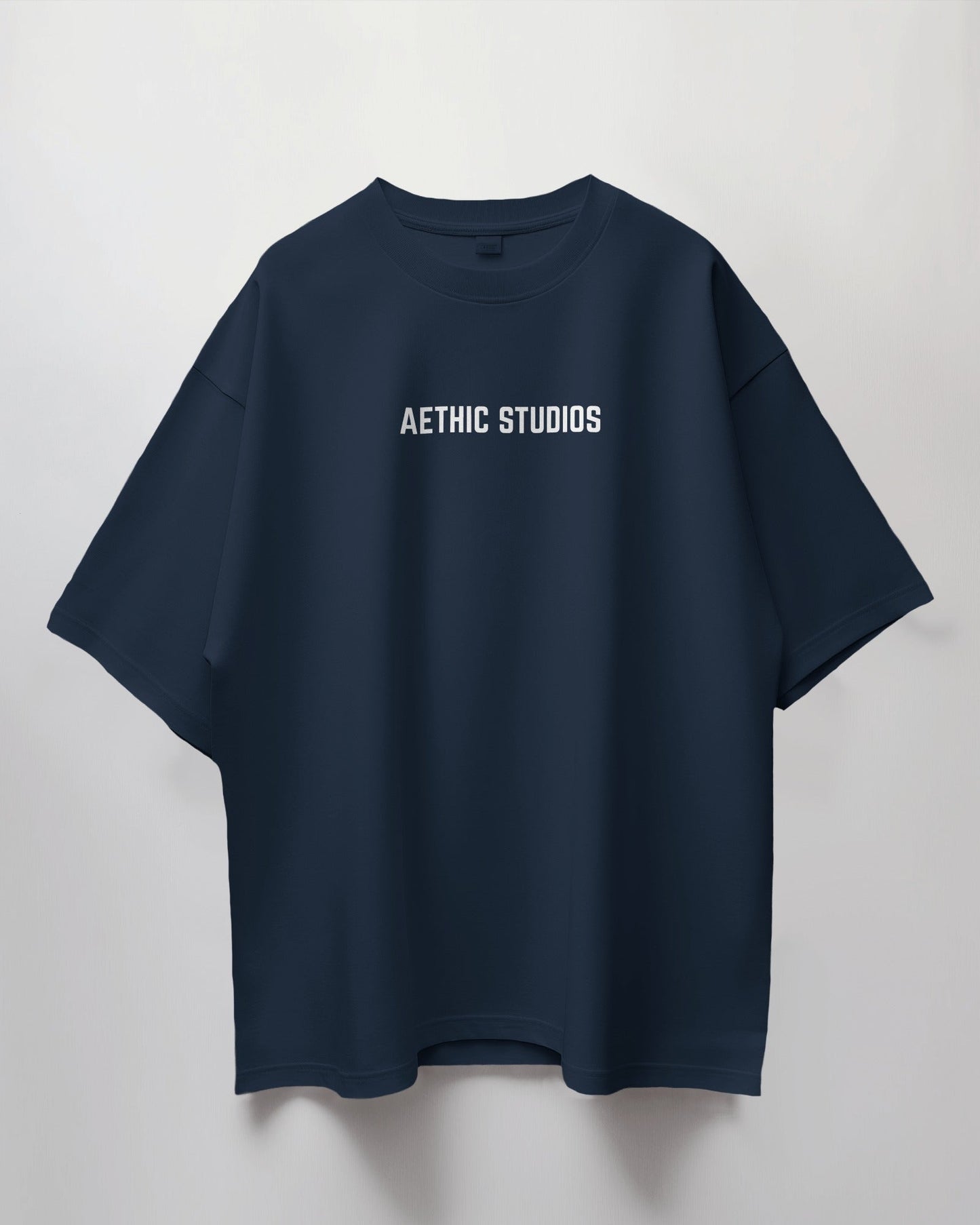 Navy blue t-shirt with 'Aethic Studios' text on a light gray background