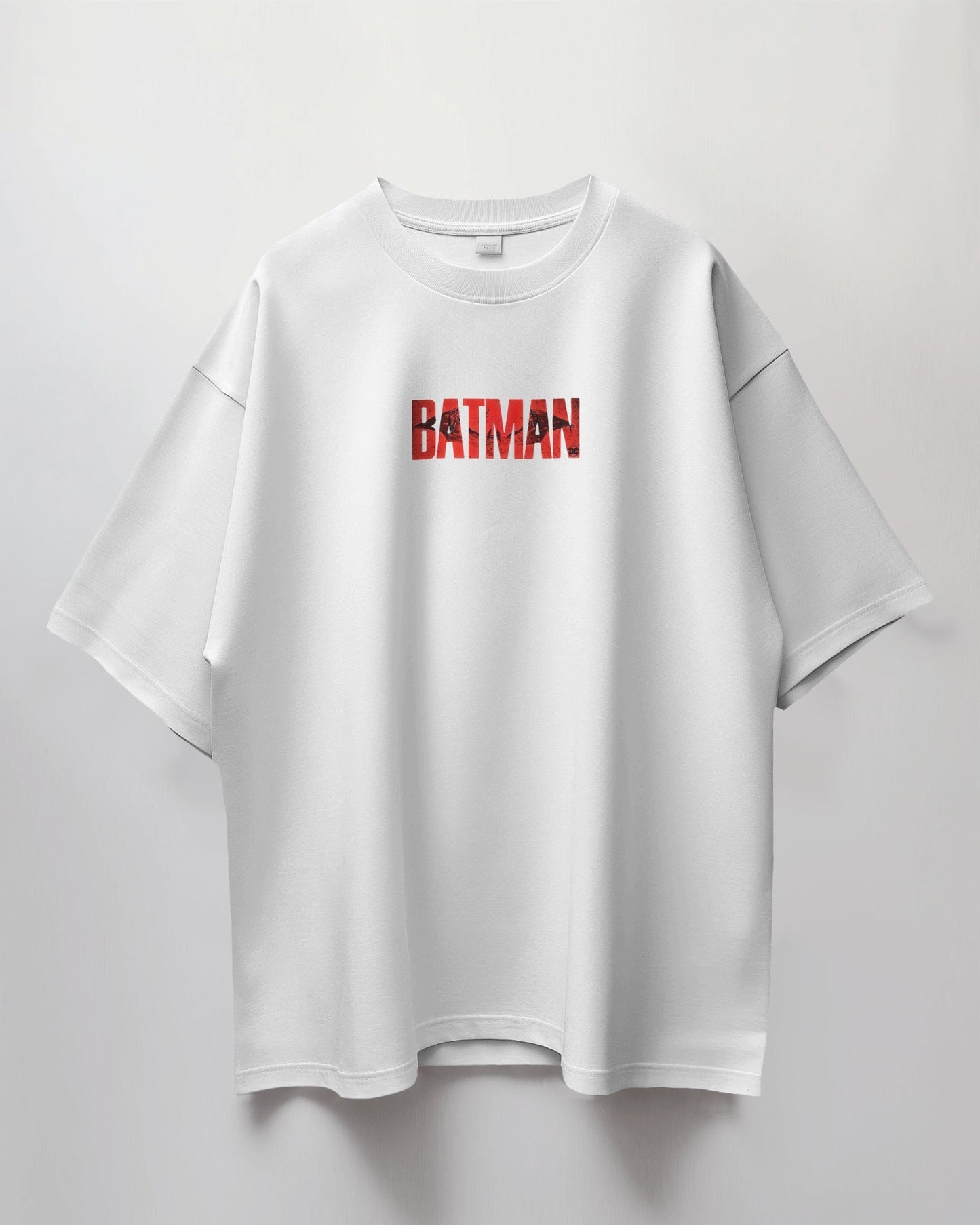 White t-shirt with 'BATMAN' logo on a light gray background