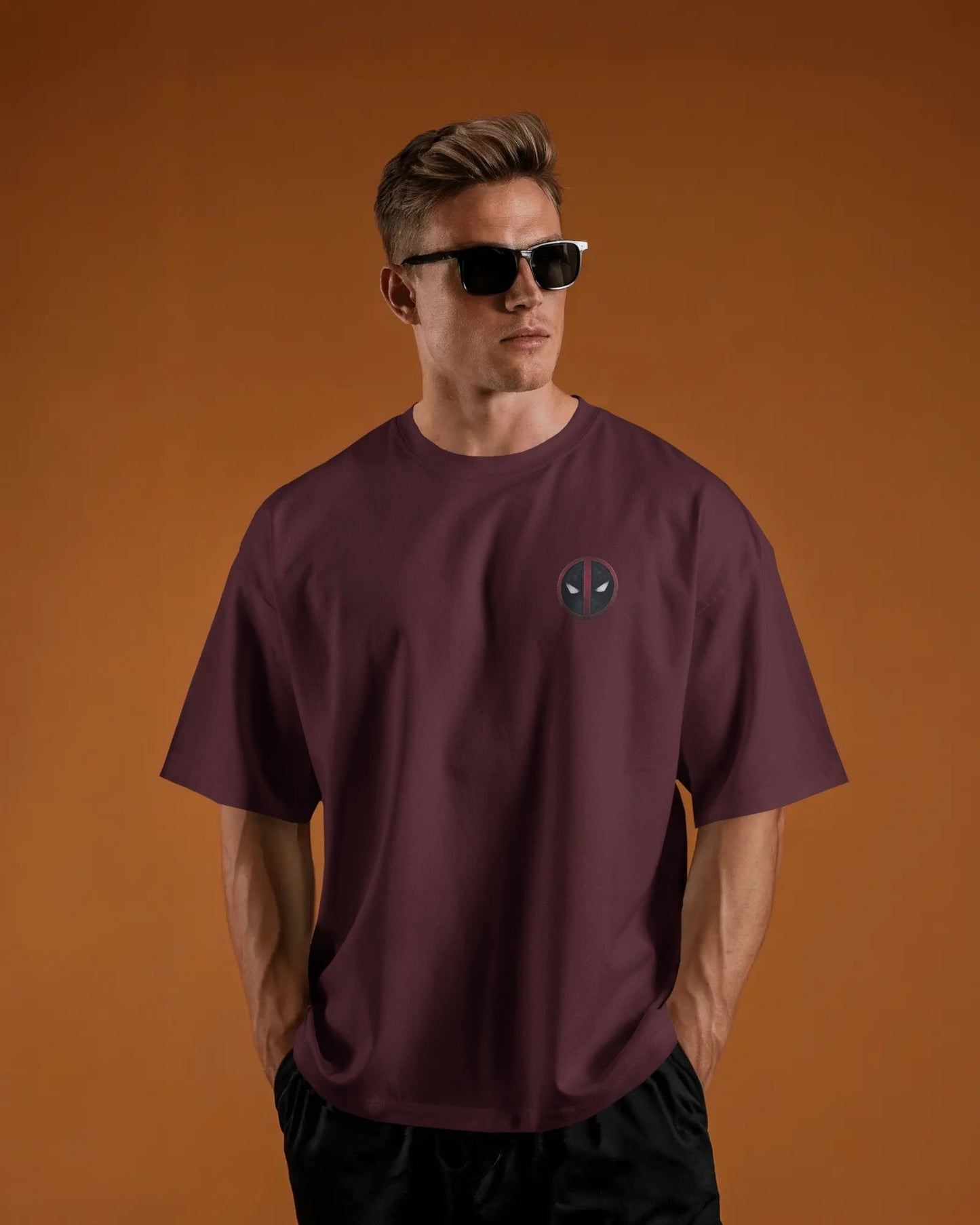 Man wearing a maroon t-shirt with a logo pf deadpool