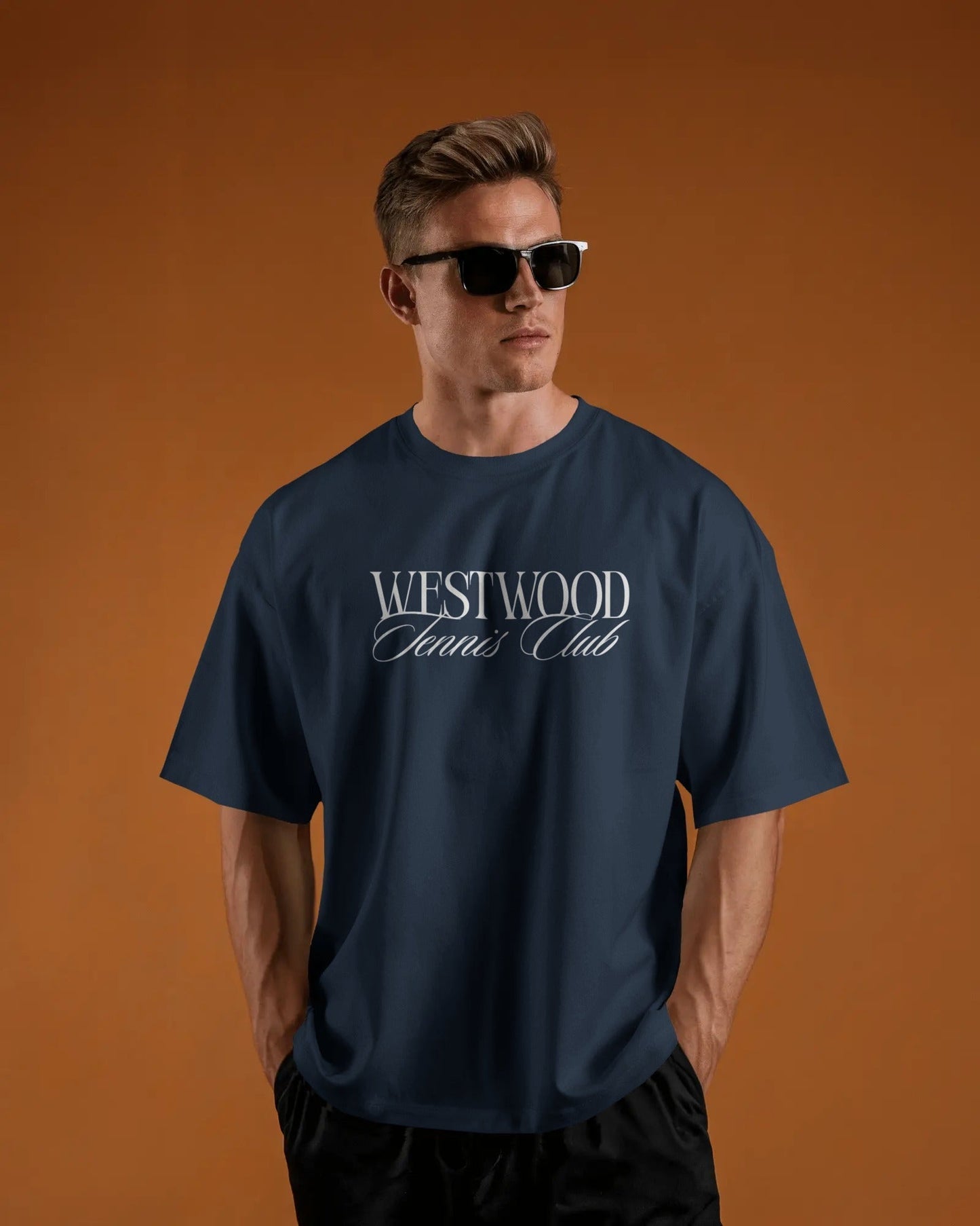 Man wearing a navy blue t-shirt with 'Westwood Tennis Club' text on an orange background
