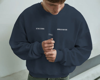 Person wearing a navy blue sweatshirt with text against a light gray background