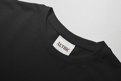 Black t-shirt with 'AETHIC' label on a light gray background